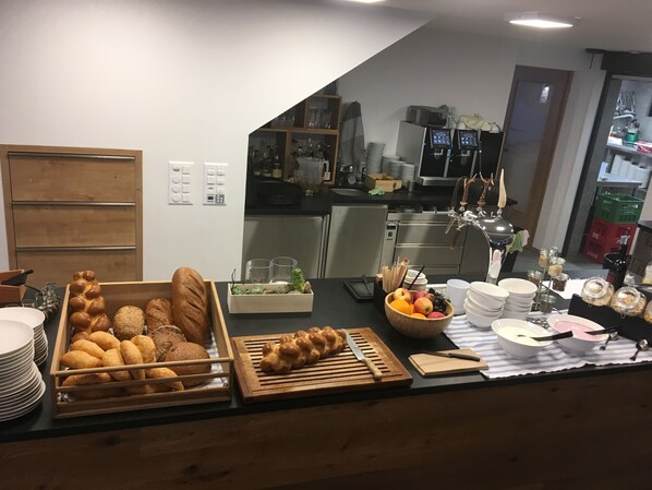 Una cocina con una exhibición de pan, un frutero y diversos electrodomésticos.