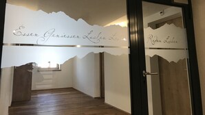 Un pasillo con piso de madera y una puerta con paneles de vidrio esmerilado.