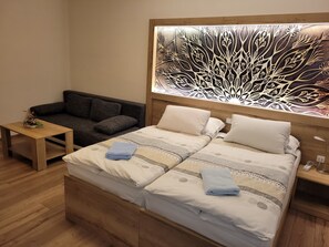 Ein ordentlich eingerichtetes Schlafzimmer mit Bett, Sofa und einem kleinen Tisch.
