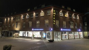 A hotel with a prominent 'HOTEL' sign, multiple balconies, and a storefront with visible signage. - Karlskrona H&H (Karlskrona)