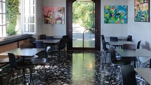 A dining area with tables and chairs, a ceiling light fixture, and artwork on the walls. - Hotel Castello S. Antonio (Lazise)