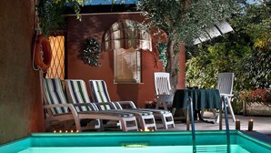 A poolside area with lounge chairs, a table with a green tablecloth, and a small pool. - Hotel Castello S. Antonio (Lazise)