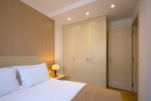 A hotel room with a bed, a nightstand, a lamp, and a wardrobe. - Spaska Apartments (Budva)