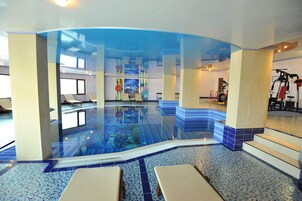 Una piscina techada, sillones reclinables de piscina