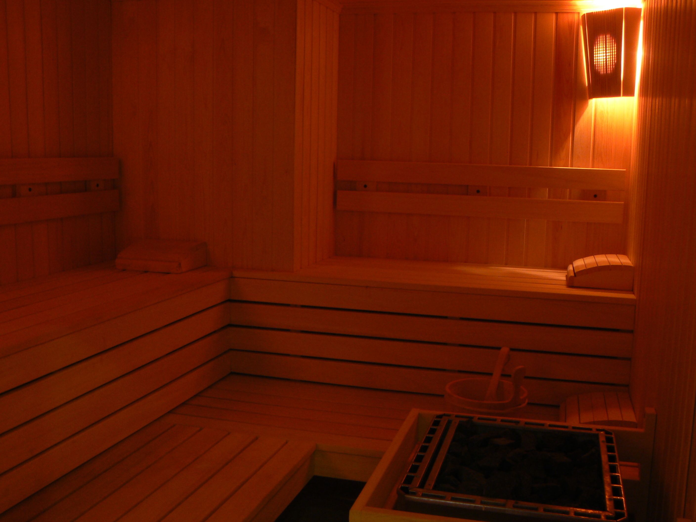Un sauna avec des bancs en bois et une banquette.