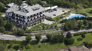 Un hotel de varios pisos con estacionamiento y piscina.