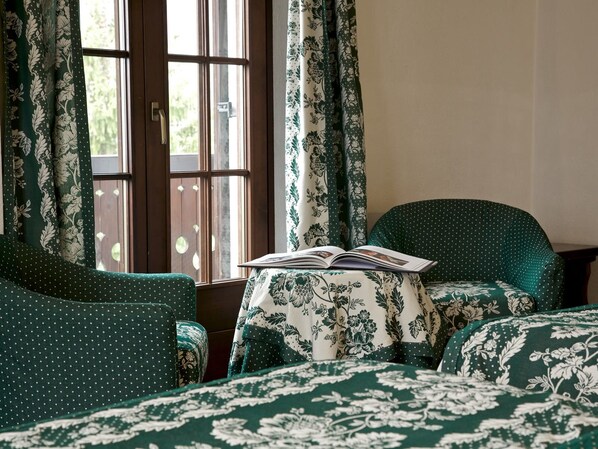 A room with a bed, a chair, and a table with a book. - Hotel Milleluci (Aosta)