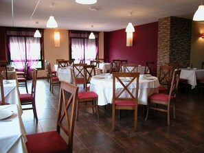 A restaurant with multiple round tables and chairs, arranged in a spacious layout. - Hotel Cachada (Sanxenxo)