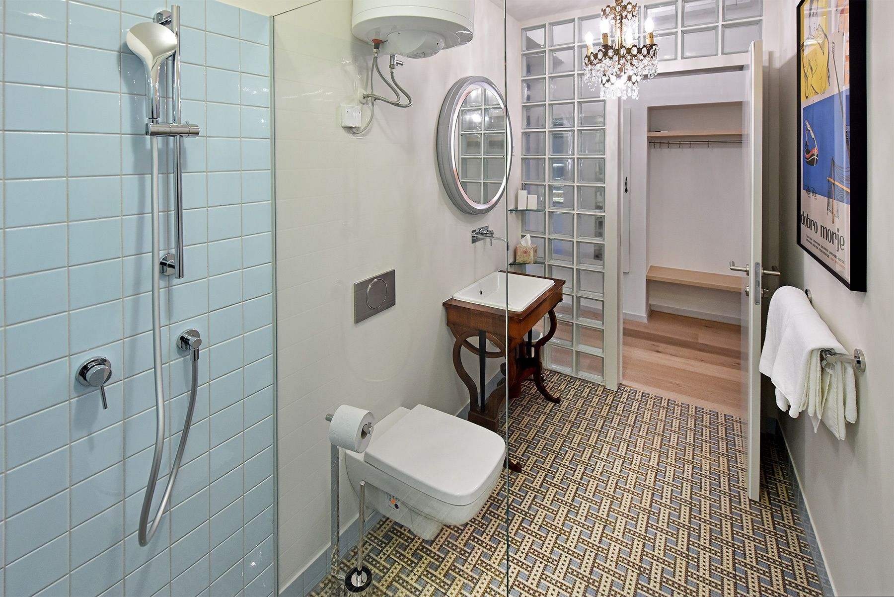 A bathroom with a shower, toilet, sink, and a mirror.