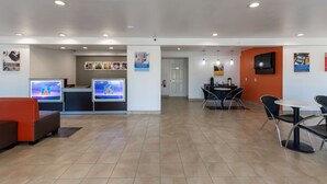 Un moderno vestíbulo de hotel con mostrador de recepción, zona de estar y comedor.
