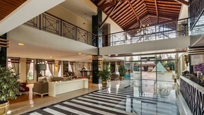 A spacious lobby with a checkered floor, a reception desk, seating area, and a balcony. - Club Hotel Felicia Village - All Inclusive (Manavgat)