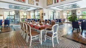 A spacious dining area with high ceilings, large windows, and a variety of table settings. - Club Hotel Felicia Village - All Inclusive (Manavgat)