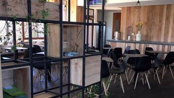 A modern office space with a wooden partition, black metal frames, and multiple workstations.