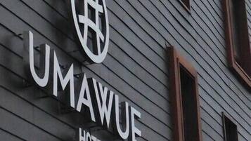 Señal de hotel con el nombre "UMAWUE HOTEL" y un logotipo.