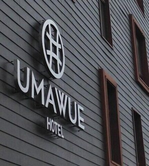 Señal de hotel con el nombre "UMAWUE HOTEL" y un logotipo.