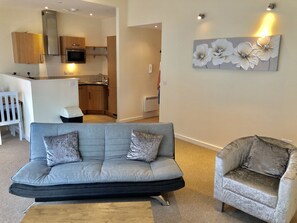 Business Apartment, 1 Bedroom | Living room | 40-inch flat-screen TV with cable channels, TV, DVD player