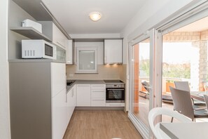 Deluxe Apartment, Ground Floor (A1) | Private kitchen | Fridge, microwave, oven, stovetop
