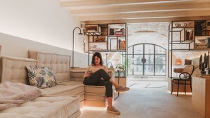 A modern living room with a beige sofa, a coffee table, and a bookshelf. -  Apartahotel Fil Suites (Palma de Mallorca)