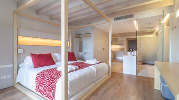 A modern bedroom with a large bed, wooden beams, a bedside table, and a bathroom visible in the background.