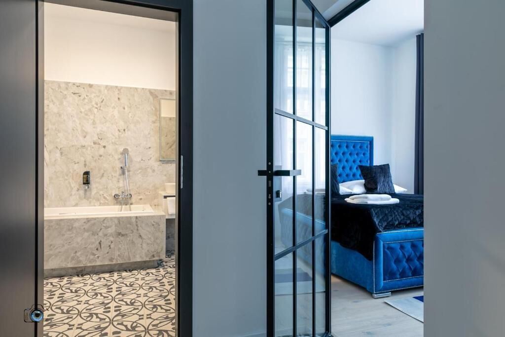 A modern bathroom with a marble wall and a patterned floor.