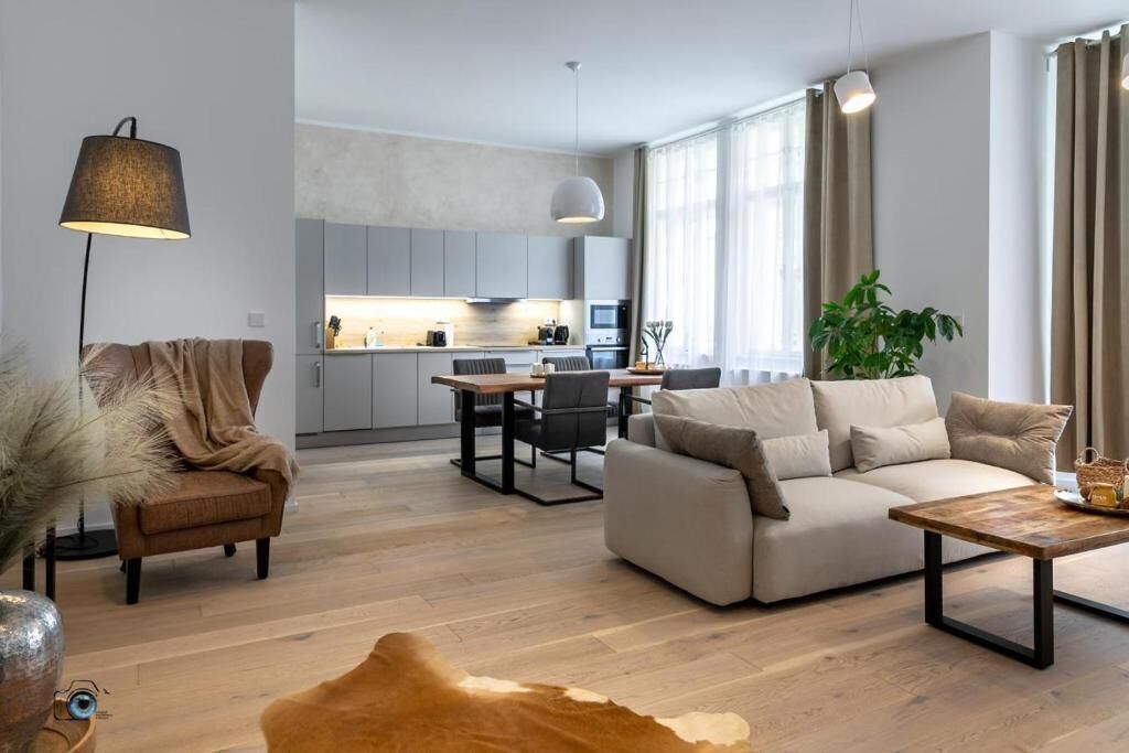 Un salon moderne comprenant un canapé, une table basse et un coin repas avec une table et des chaises.