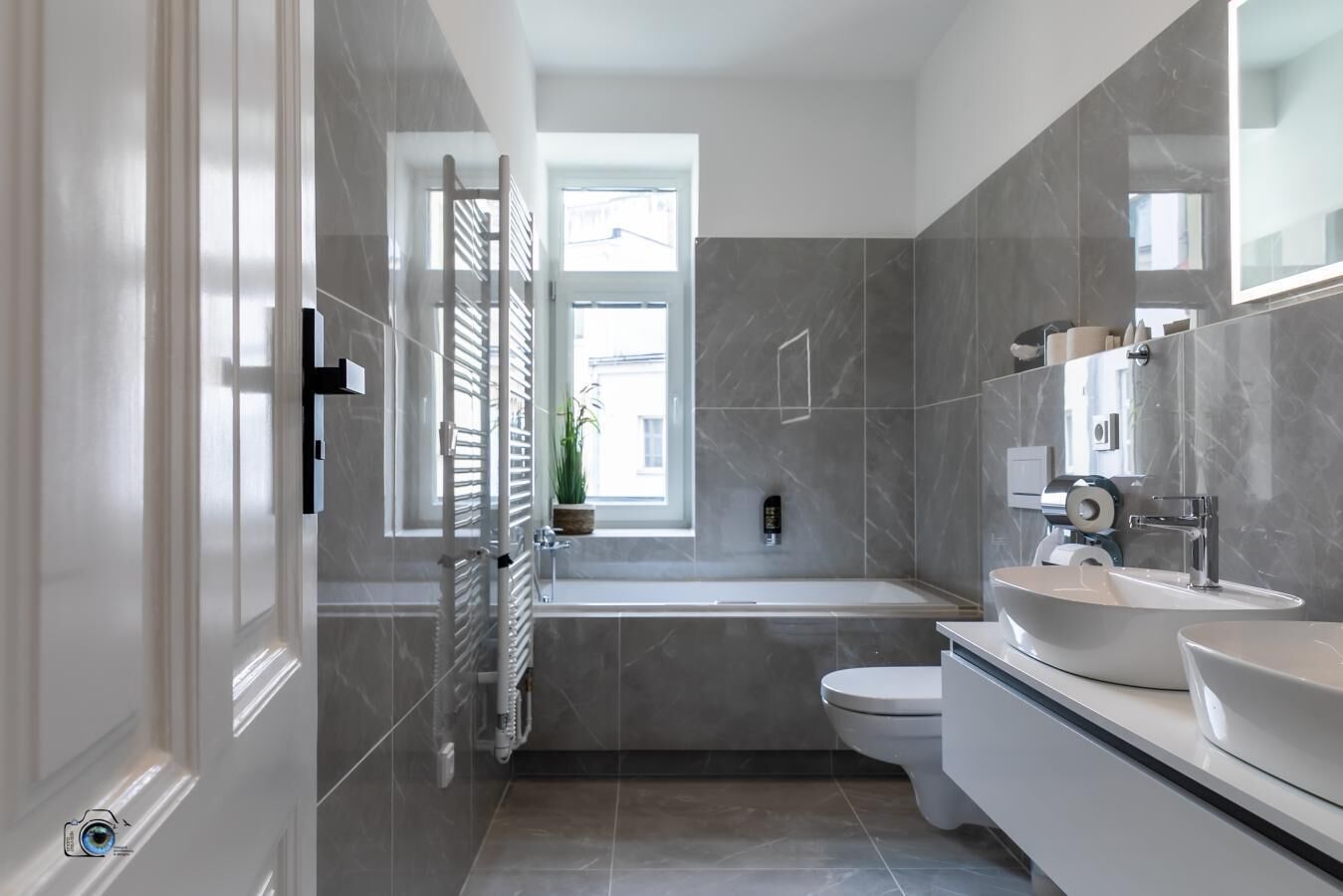 A modern bathroom with a bathtub, toilet, and sink.