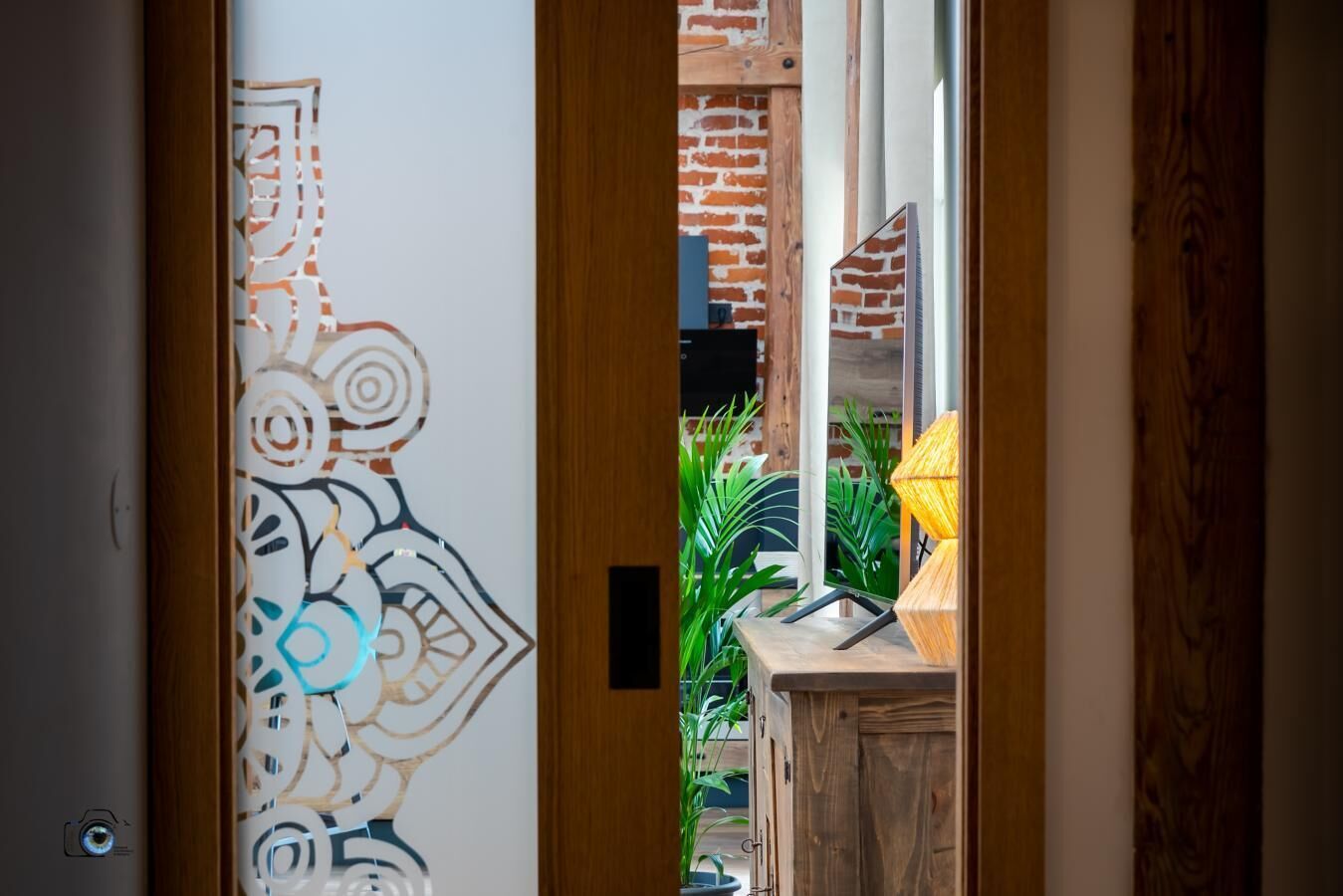 A doorway with a decorative glass panel, a wooden bench, and a lamp.