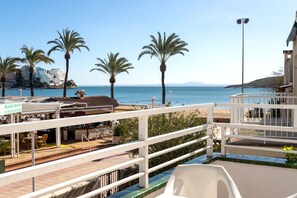 A seaside view with a restaurant named "Ancla Verde" and a white railing overlooking the beach. - Neighbours Apartments (Calvia)
