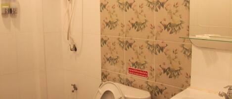 A bathroom with a toilet, bidet, and sink.