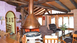 Ein rustikales Interieur mit großem Kupferkocher, Holzmöbeln und Backsteinwänden.
