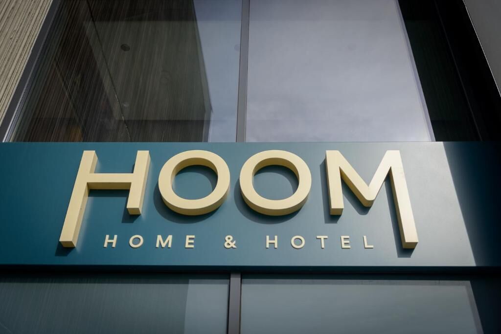A sign for 'HOOM HOME & HOTEL' with a modern design.