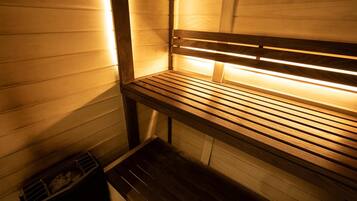 Uma sauna com bancos de madeira e um banco no chão.