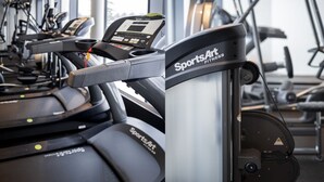A row of stationary bikes with digital displays, branded as 'SportsArt Fitness'. - Hoom Home & Hotel (Jarfalla)