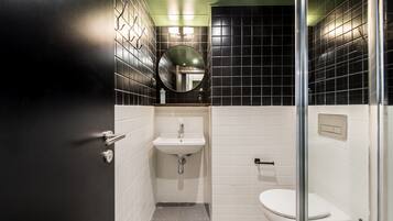 A bathroom with a sink, toilet, and a mirror.