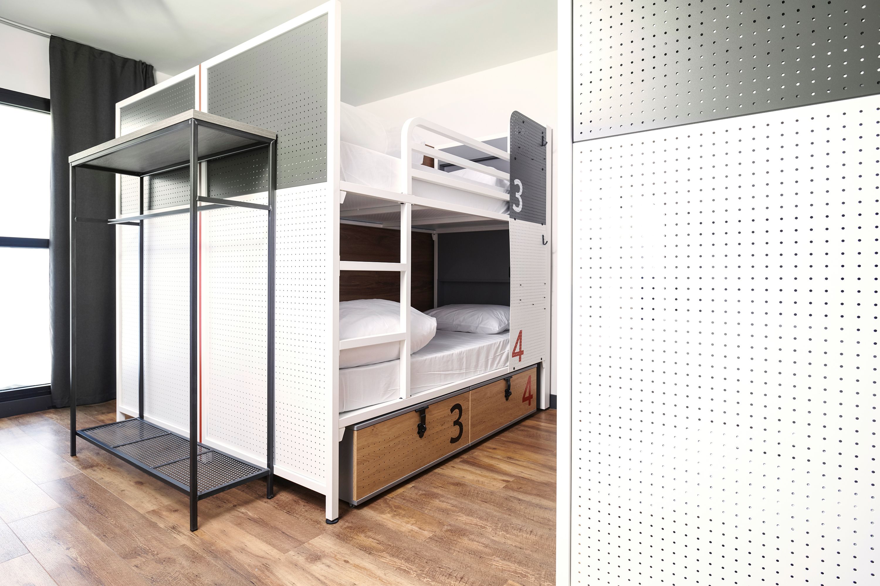 A bunk bed with storage drawers, a metal shelf, and a number board.