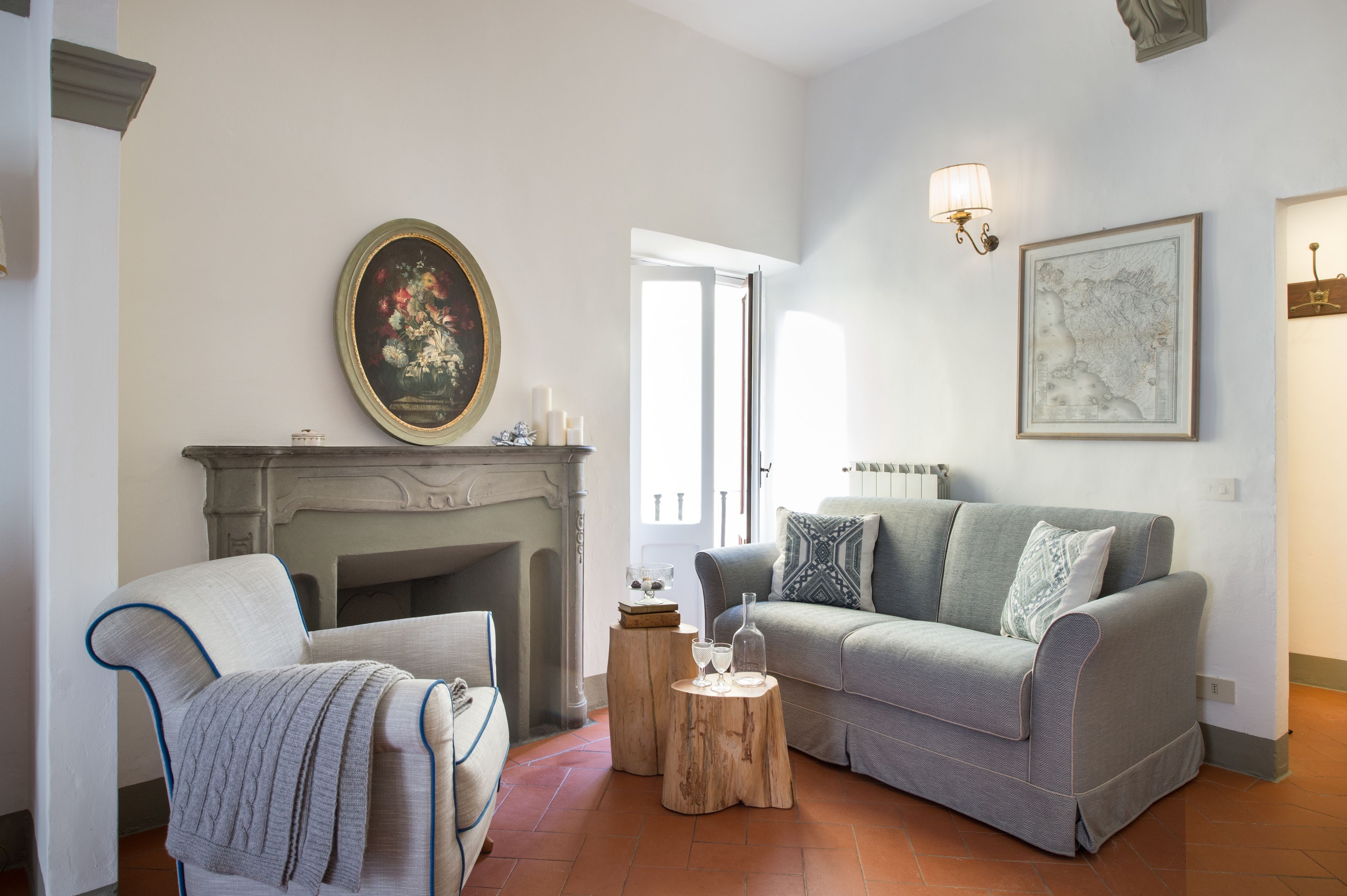 Un salon avec une cheminée, un canapé, un fauteuil et une table basse.