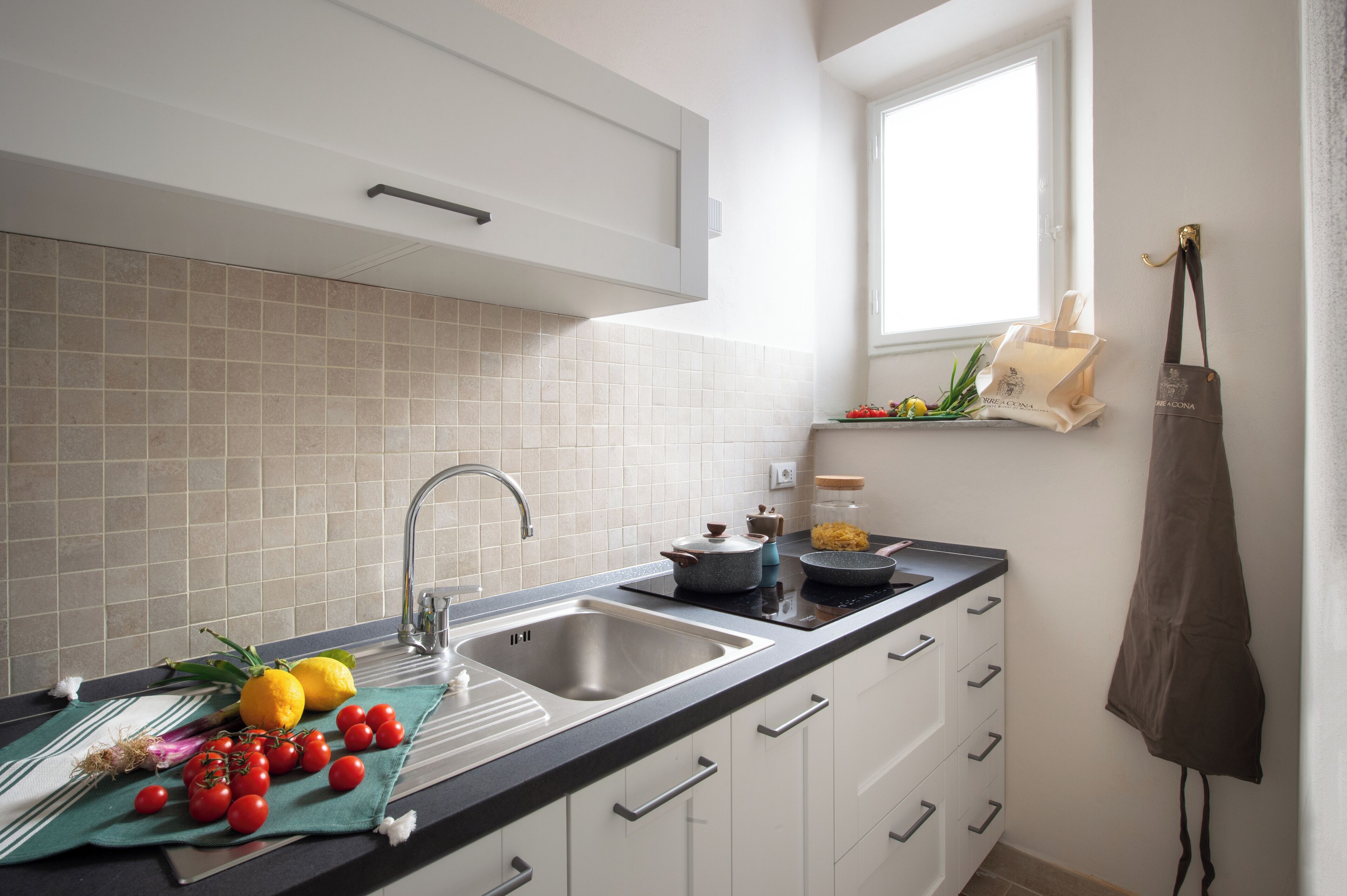 Een moderne keuken met een spoelbak, aanrecht en raam.