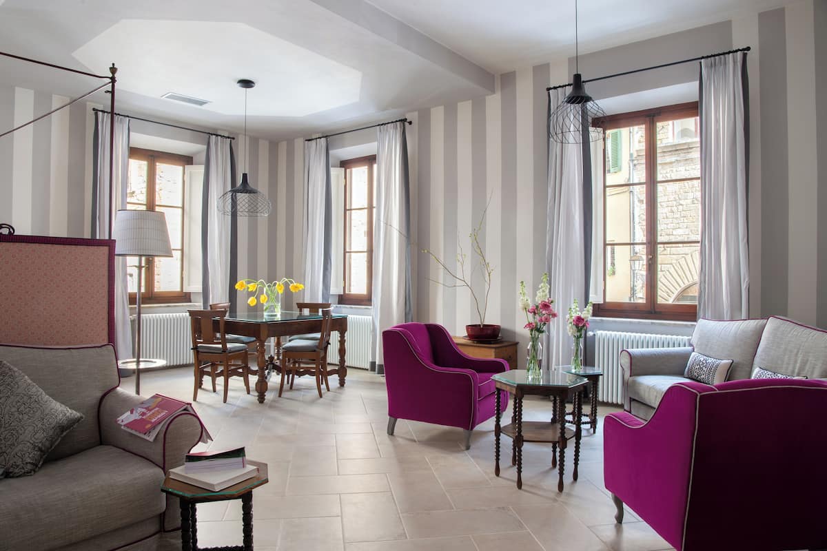 A living room with striped walls, a dining area with a table and chairs, and a sofa.