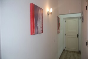 A hallway with a white door, a light switch, and two wall-mounted light fixtures. - Suites Inn Lagos (Lagos)