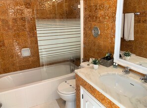 A bathroom with a bathtub, toilet, and sink. - Suites Inn Lagos (Lagos)