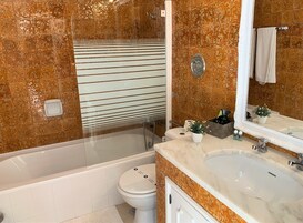 A bathroom with a bathtub, toilet, and sink.