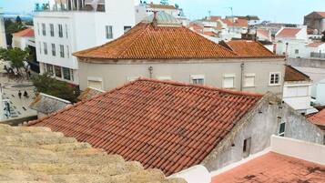 A building with a red-tiled roof and a courtyard with a fountain.