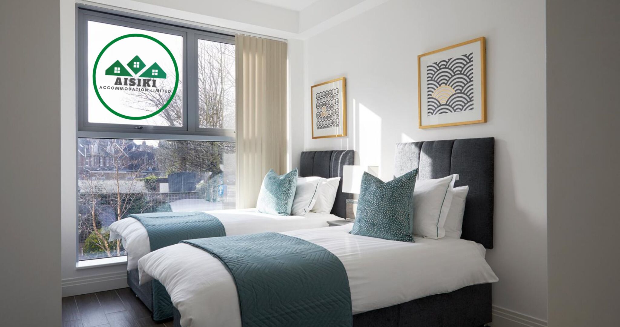 Een hotelkamer met twee bedden, een groot raam en kunstwerken in lijsten aan de muur.