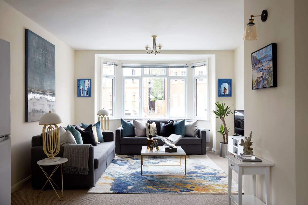 A living room with a sofa, coffee table, and a large window.