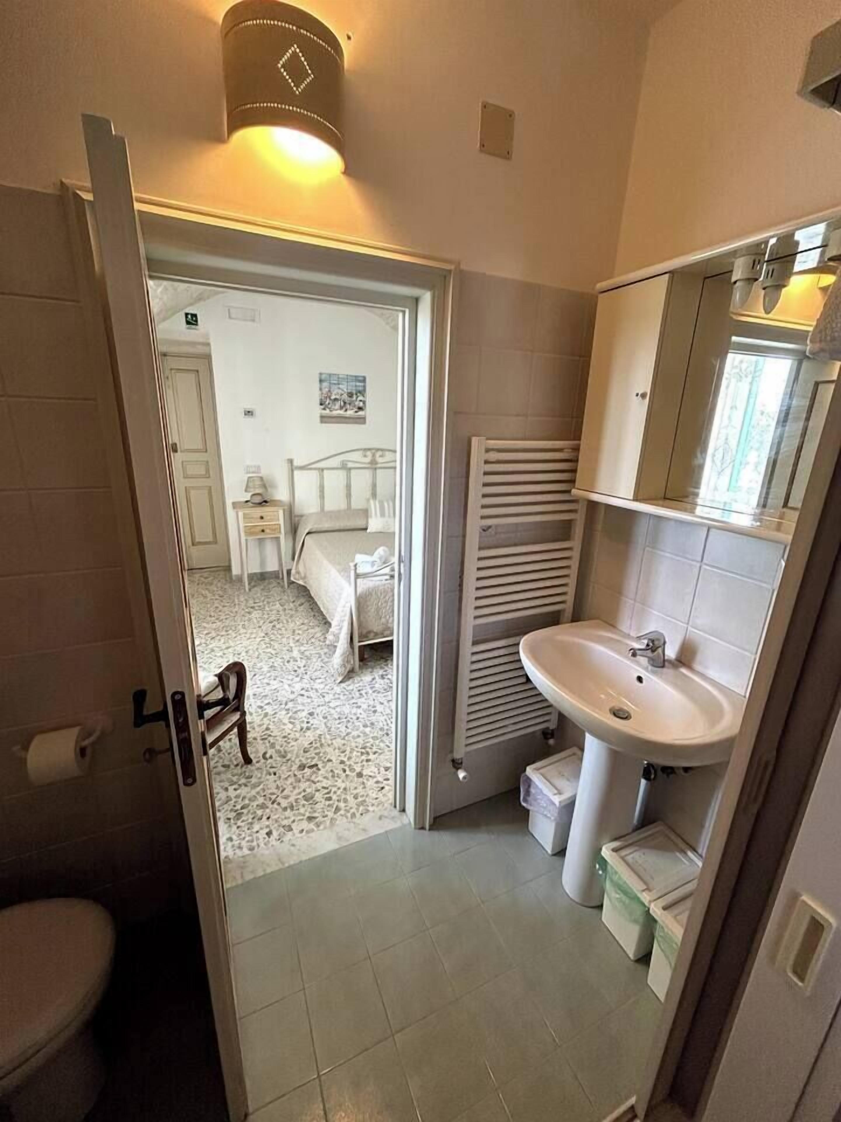 A bathroom with a sink, mirror, and toilet.