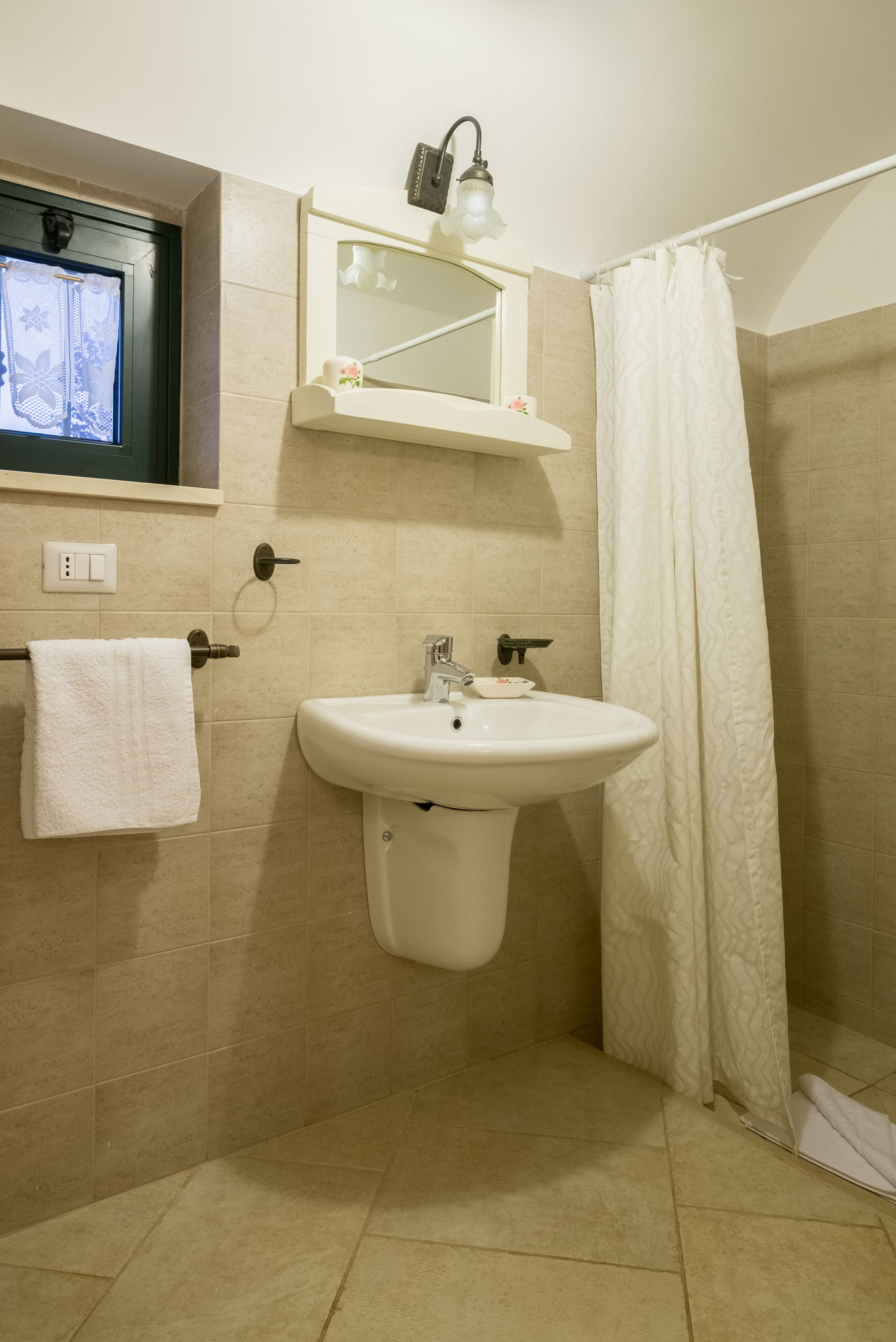A bathroom with a sink, mirror, and shower curtain.