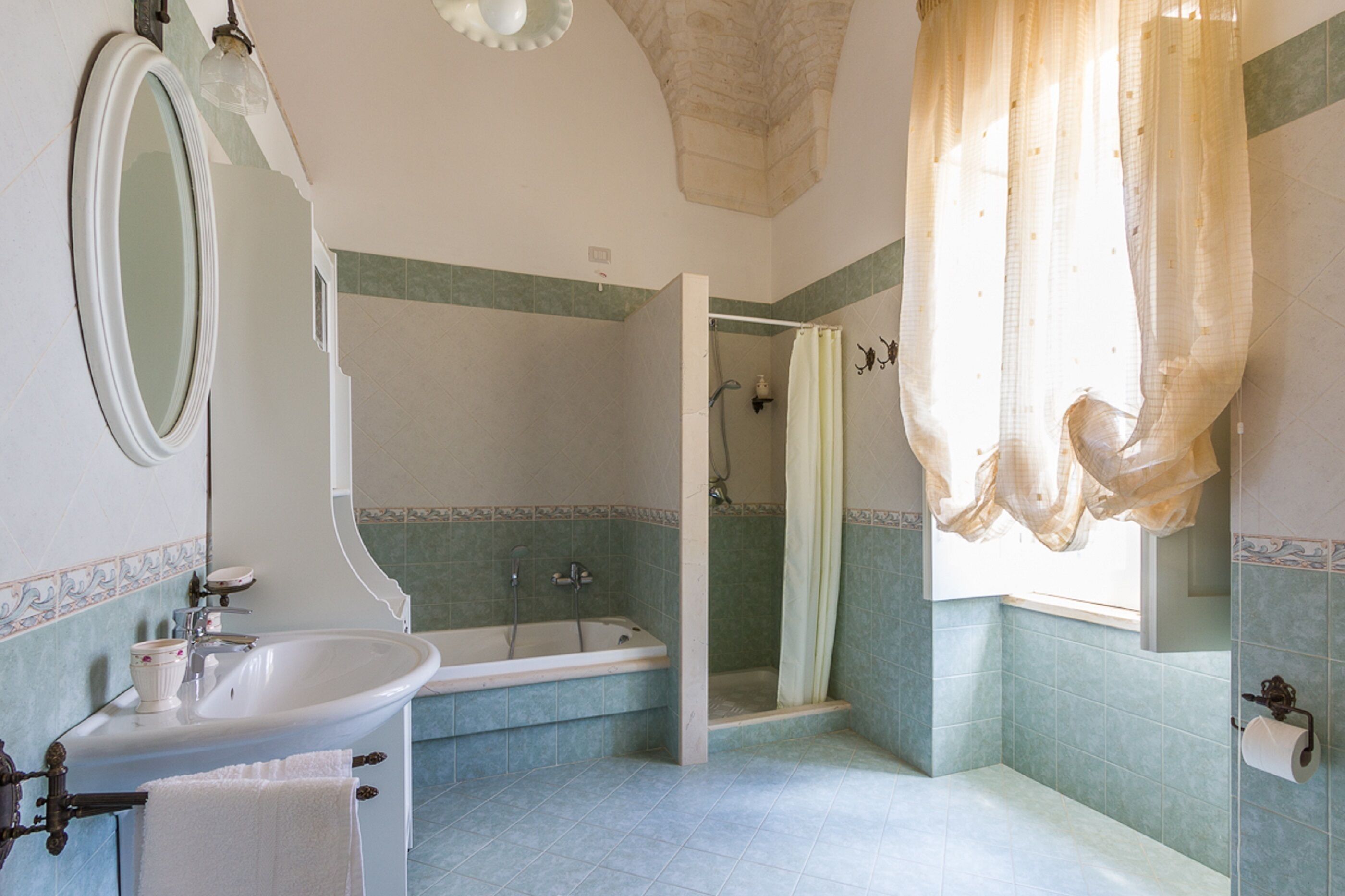 Un baño con bañera, lavamanos, espejo y cortina de ducha.