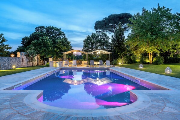 En säsongsöppen utomhuspool och solstolar