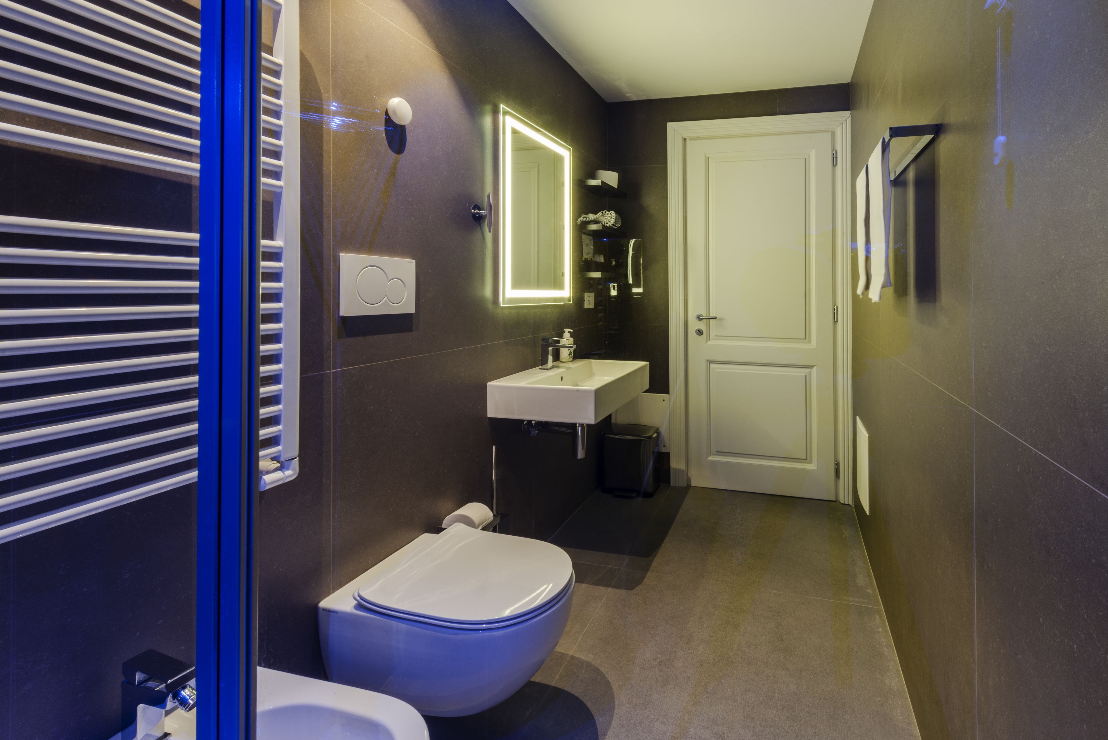 A modern bathroom with a toilet, sink, and mirror.