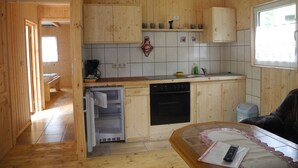 Una cocina compacta con armarios de madera, lavavajillas y refrigerador.